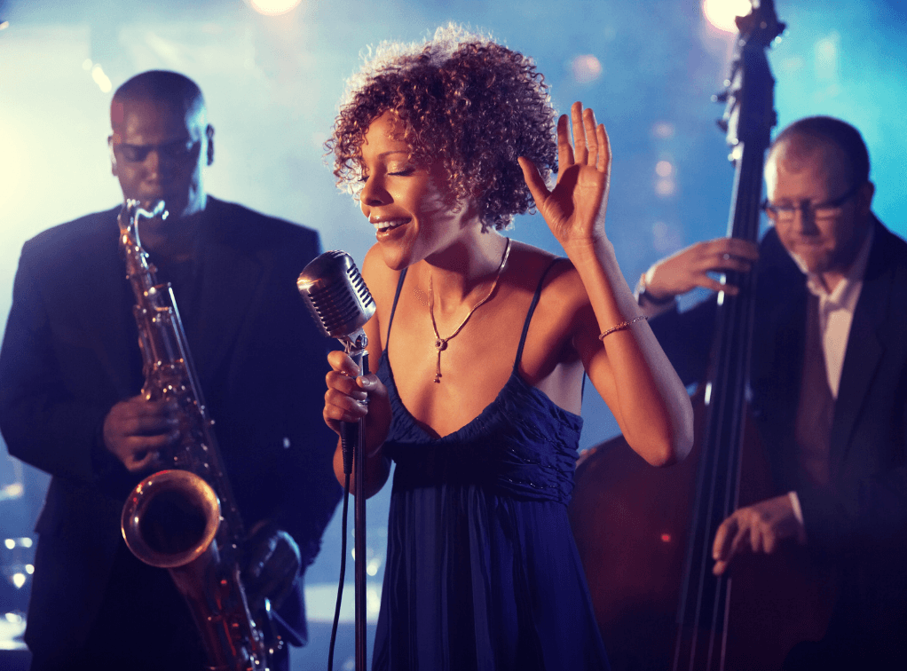 Jazztrio på scenen med saksofon, vokalist og kontrabass